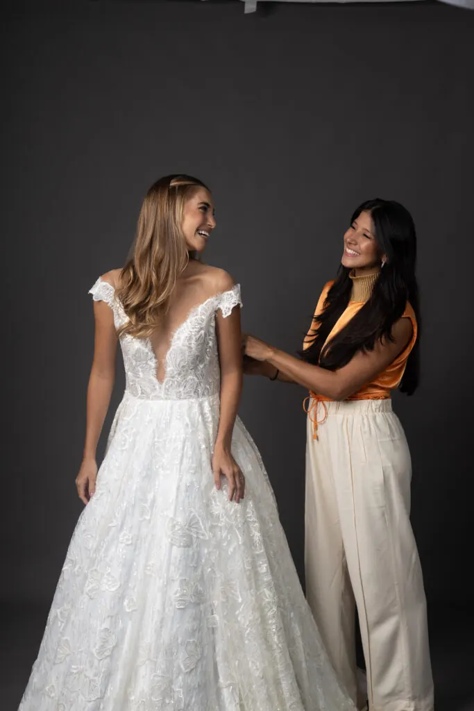 Estilista ajustando o vestido de noiva durante a prova