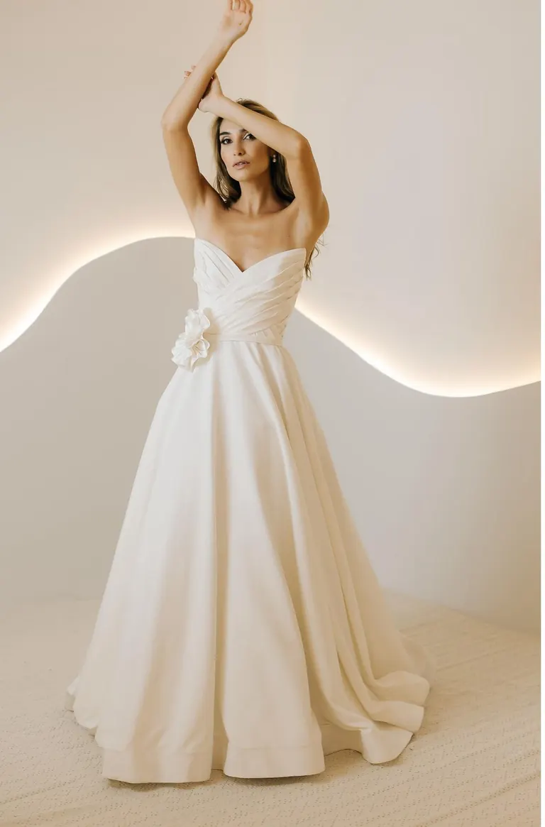 Vestido de noiva com decote transpassado e flor no ombro
