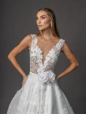 Vestido de noiva Lorette: renda floral em relevo, decote em V e flor na cintura. Coleção Ateliê Guinza