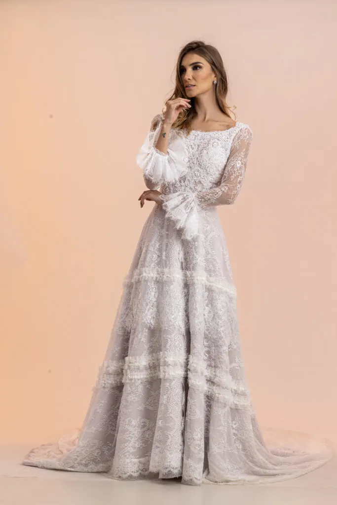 Vestido de noiva de renda com mangas longas bufantes e saia em camadas