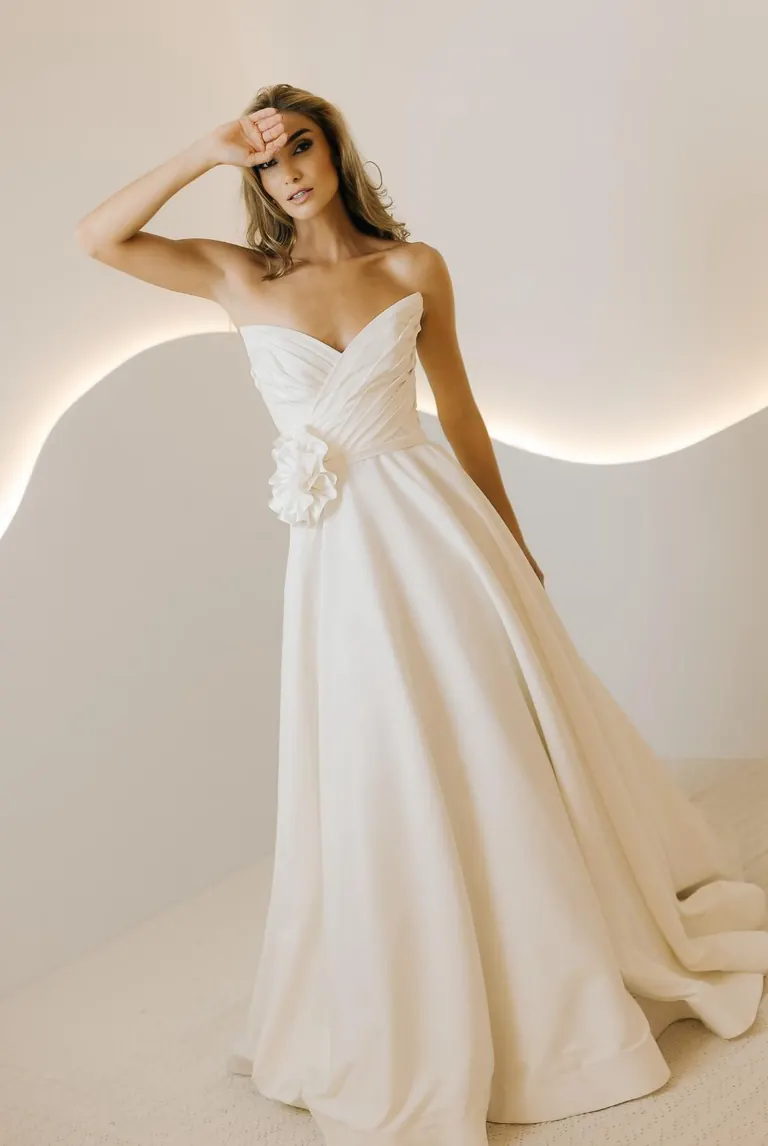 Noiva com vestido de saia ampla e flor aplicada no ombro