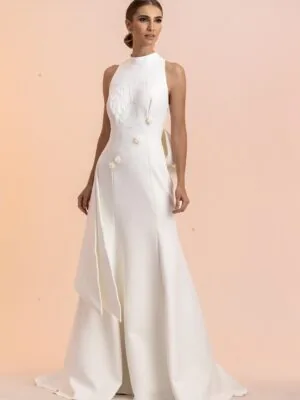 Vestido de noiva Verona: gola alta sem mangas, botões florais e sobreposição lateral. Coleção Ateliê Guinza